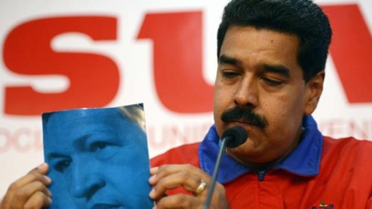 Maduro muestra la portada de un libro de Hugo Chávez durante una conferencia de prensa, el día 11 en Caracas.