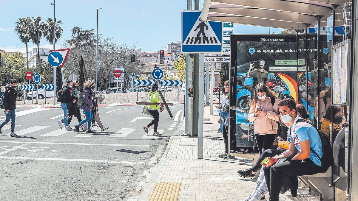 Jóvenes esperan en una de las paradas del autobús urbano en la avenida de Héroes de Baler.