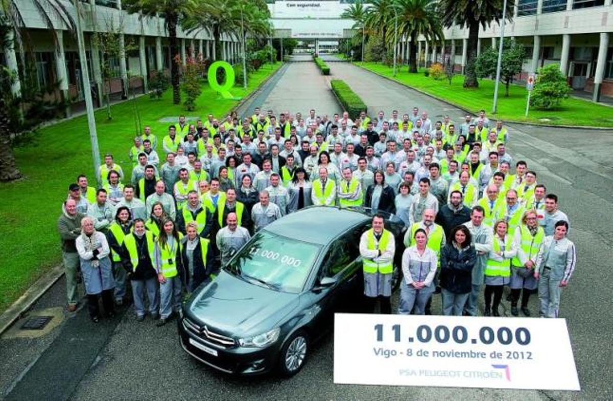 Foto de familia de los directivos y algunos trabajadores de PSA Peugeot Citroën en Vigo, con el vehículo 11 millones, un C-Elysée gris.  // PSA
