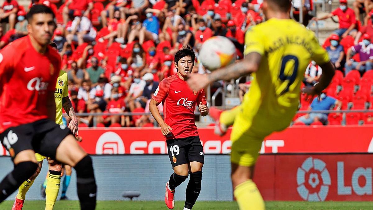 Kang In Lee, que salió al campo en el minuto 90, observa cómo Alcácer controla la pelota.  | EFE/CATI CLADERA