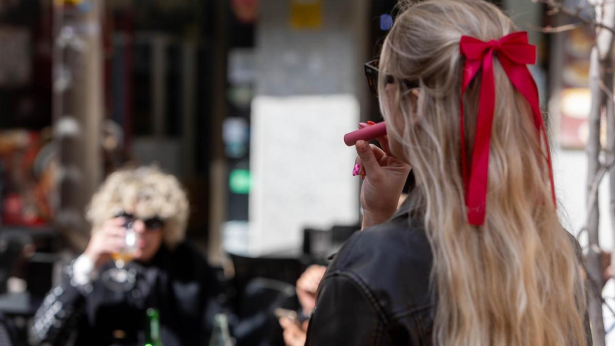 Una joven vapea por las calles de Alicante