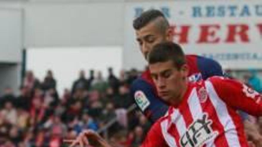 Pere Pons prova una passada davant l&#039;oposició d&#039;un jugador de l&#039;Osca.