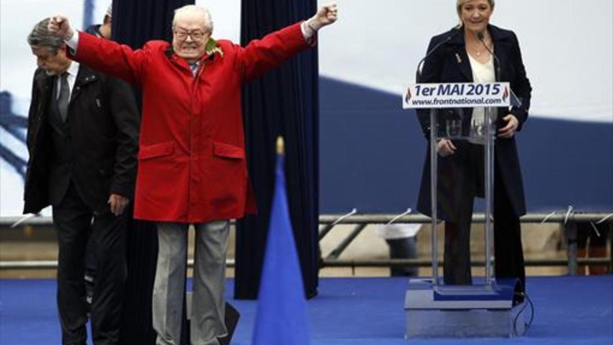 Jean-Marie Le Pen gesticula junto a su hija y presidenta del FN, Marine, en un acto del partido en París.