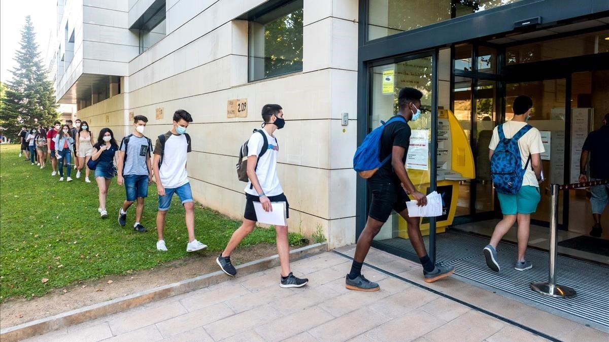 Los alumnos que se disponen a realizar la prueba de selectividad, en fila de a uno,entran en la Universitat de Lleida.