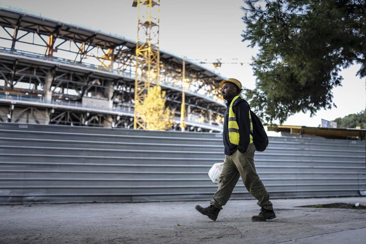 Un operario pasa por delante de las obras del Camp Nou.