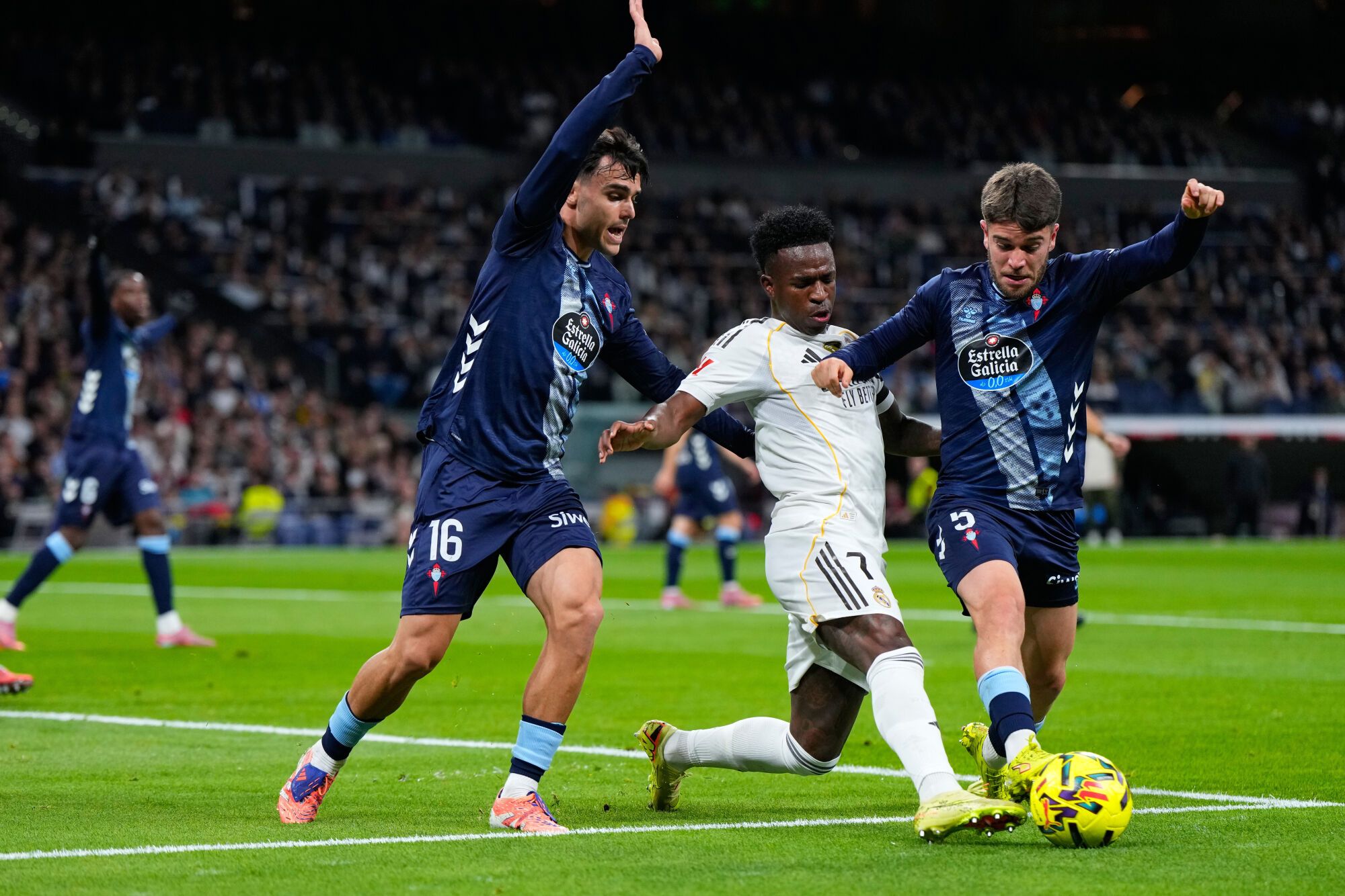 Real Madrid's Kylian Mbappe is challenged by Celta's Sergio Carreira, right, and Miguel Roman during the Spanish La Liga soccer match between Real Madrid and Celta Vigo in Madrid, Spain, Sunday, Dec. 7, 2025. (AP Photo/Manu Fernandez)