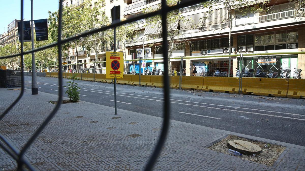 Vallas y un cartel de aviso por obras en la calle Comte d'Urgell, entre Diputació y Aragó, en Barcelona.