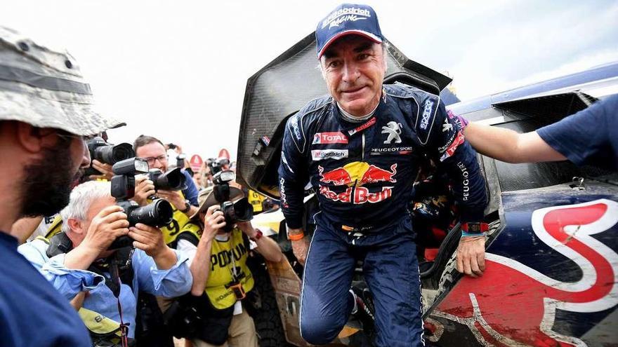 Carlos Sainz baja de su coche tras finalizar la última etapa y asegurarse la victoria en el Dakar. // Reuters