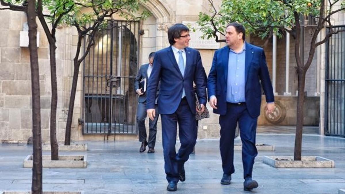 El 'president' Carles Puigdemont y el vicepresidente Oriol Junqueras, este martes, dirigiéndose a la reunión del Govern.