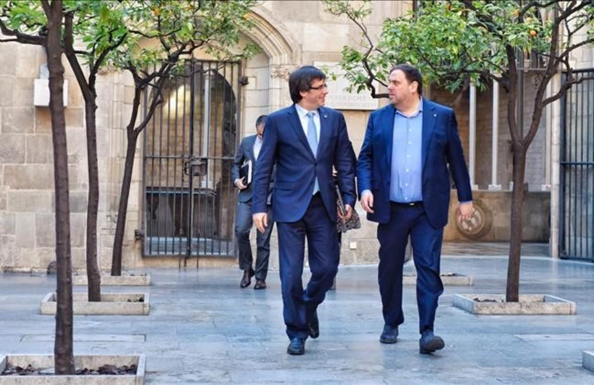 El 'president' Carles Puigdemont y el vicepresidente Oriol Junqueras, este martes, dirigiéndose a la reunión del Govern.