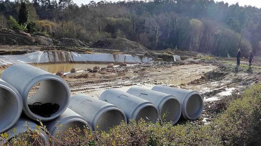 Vecinos miran una de las balsas de mayor tamaño (al lado, otra más pequeña), cerca de la rúa Xenza.