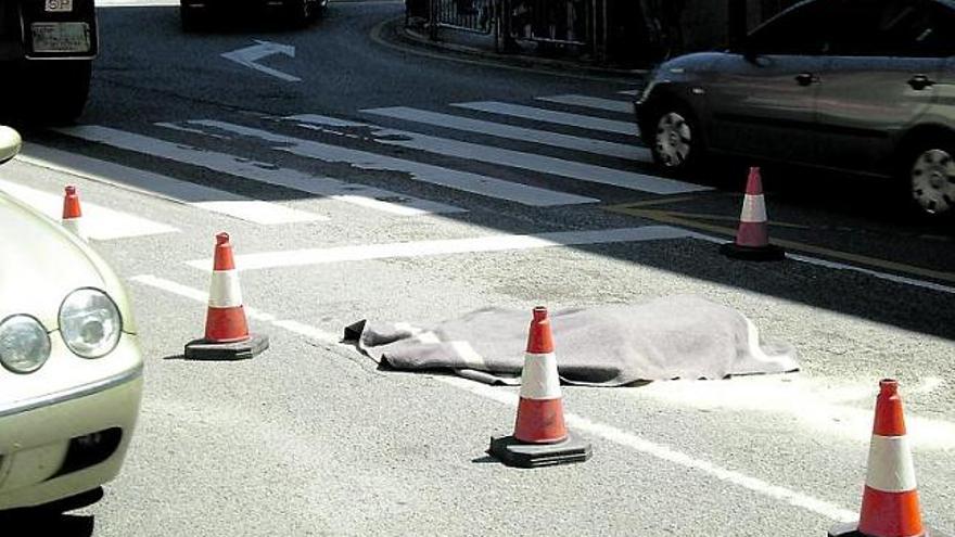 El cuerpo de G. R. G., tapado con una manta, instantes después del accidente, ayer, en Posada de Llanera.