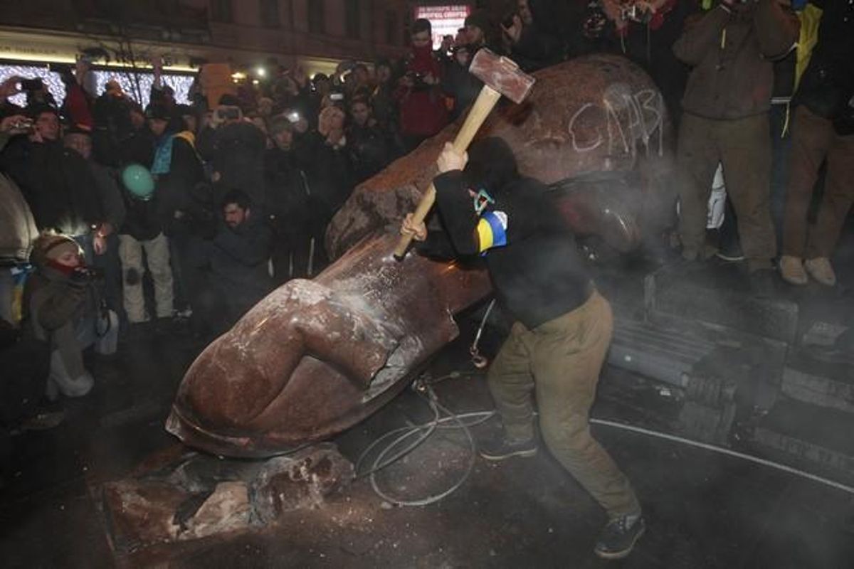 Alguns manifestants destrossen l’estàtua de Lenin a Kíev després de fer-la caure.