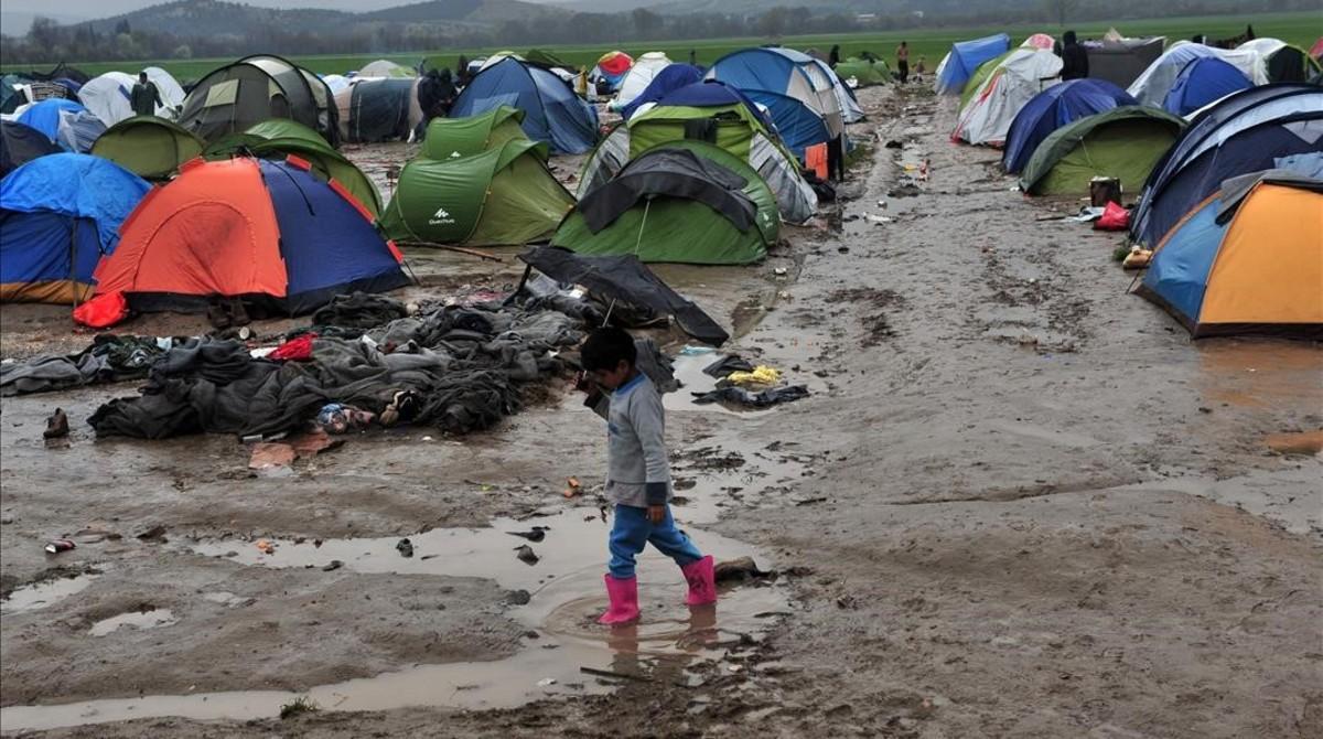 Un niño camina entre el barro en un campo de refugiados próximo a la frontera con Macedonia, cerca de Idomeni (Grecia).