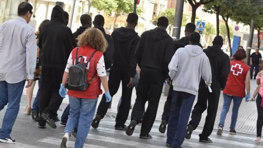 Los inmigrantes paseando por las calles de Elda acompañados por los voluntarios de Cruz Roja.