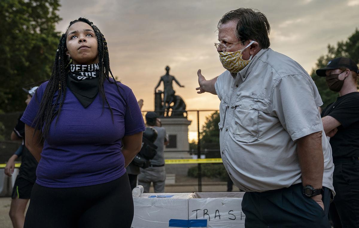 Un hombre y una joven discuten sobre eliminar el Monumento a la Emancipación, en Lincoln Park, en Washington. El Monumento muestra a Lincoln con la Proclamación de la Emancipación en una mano y con la otra apoyada sobre la cabeza de un hombre negro en taparrabos, arrodillado a sus pies. 