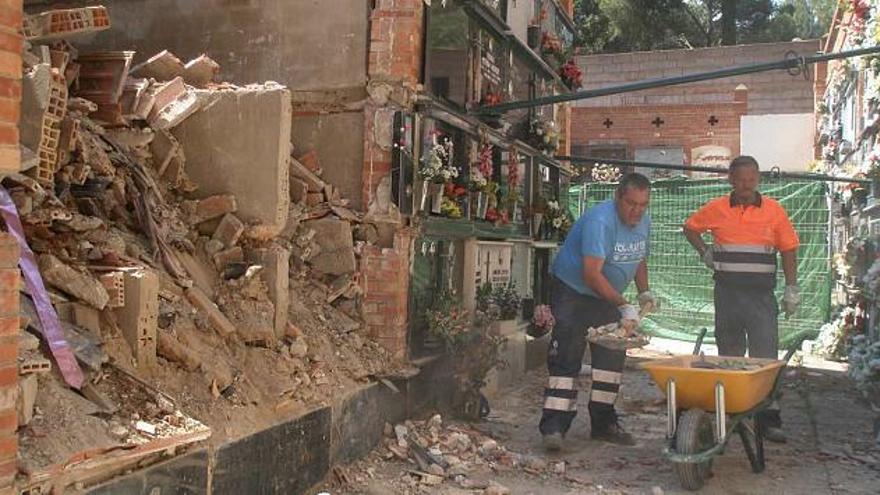 Un trabajador retira con una pala restos de construcción acumulados en el suelo para extraerlos del cementerio.