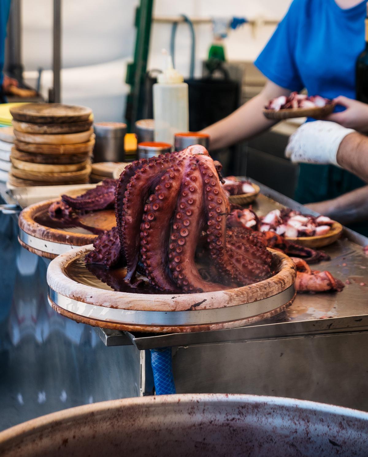 Pulpo gallego cocido, con las pulpeiras sirviéndolo.