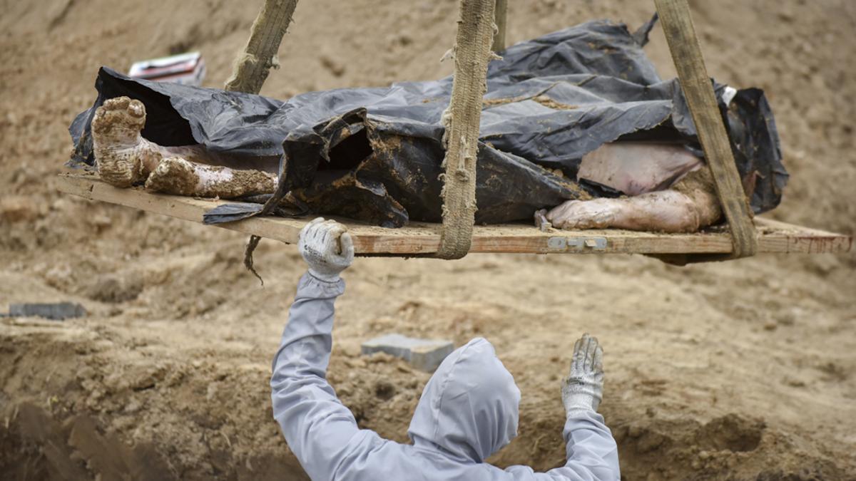 Un trabajador exhuma un cadáver de una fosa común cerca de la Iglesia de San Andrés y Todos los Santos, en Bucha, Ucrania, el 13 de abril de 2022. Investigadores forenses procedieron a la exhumación de una fosa común con más de 410 cadáveres de civiles. El Consejo de Derechos Humanos de la ONU decidió proceder a una investigación sobre los delitos cometidos por Rusia tras la invasión a gran escala de Ucrania el pasado 24 de febrero.