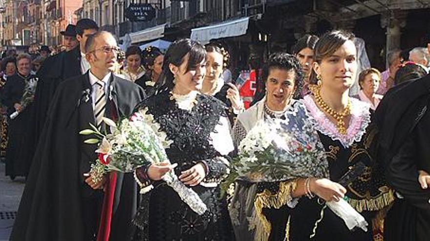 Las mujeres participantes en el desfile portan ramos de flores para entregar a la patrona.