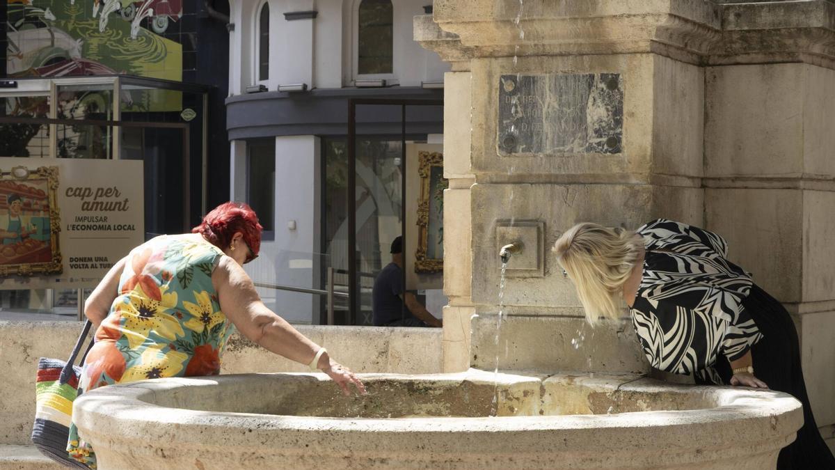 Gente refrescándose en la Font del Lleó de Xàtiva durante la ola de calor.