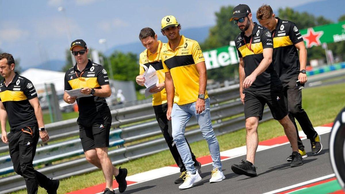 Carlos Sainz, con los miembros de su equipo técnico, analizando a pie un circuito