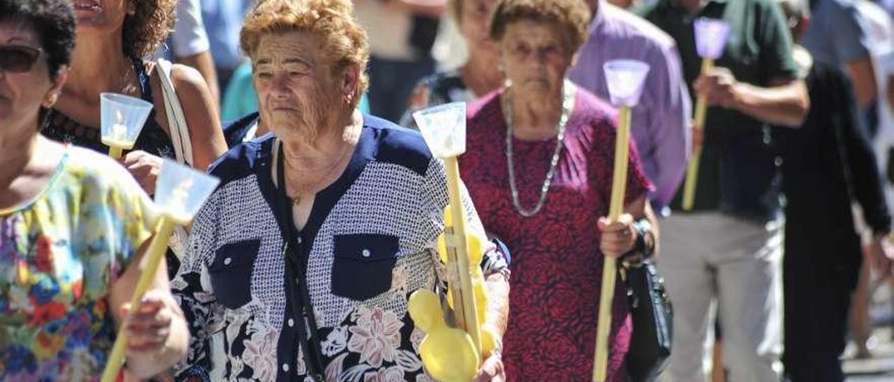 Los fieles llevaron exvotos y velas encendidas durante la procesión. // Iñaki Abella