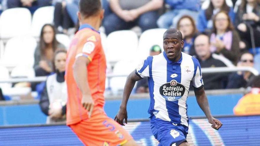 Ola John conduce la pelota ante un rival ayer en Riazor.