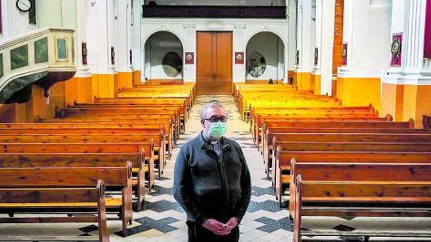 El cura en la Iglesia vacía sin feligreses ante la ausencia de misas.