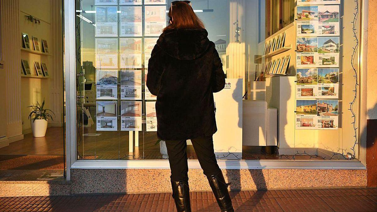 Una mujer observa las ofertas en una inmobiaria de A Coruña.