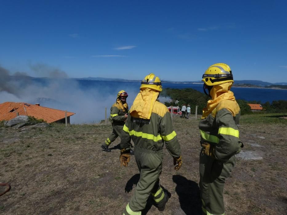 Las exhaustas labores de extinción del incendio de Cangas. // S. Álvarez