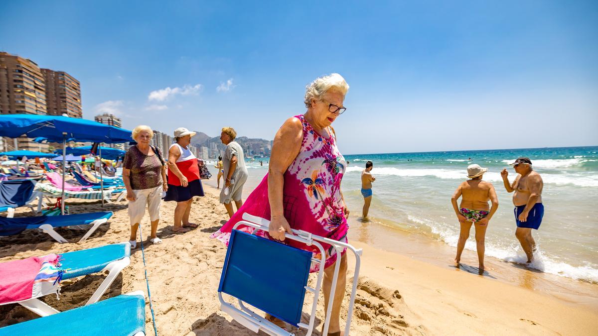 Una mujer, con su hamaca, este verano en una playa de Benidorm