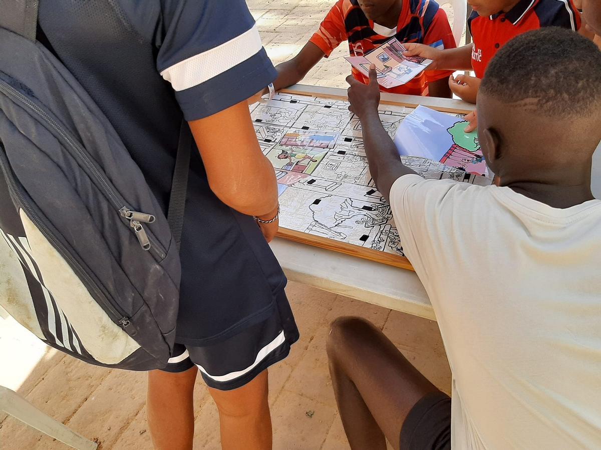 Niños hacen un puzle sobre hábitos responsables en las calles en el parque Manuel Navarrete, en Málaga