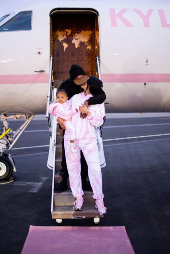 Kylie Jenner y Travis Scott besándose con su hija en brazos