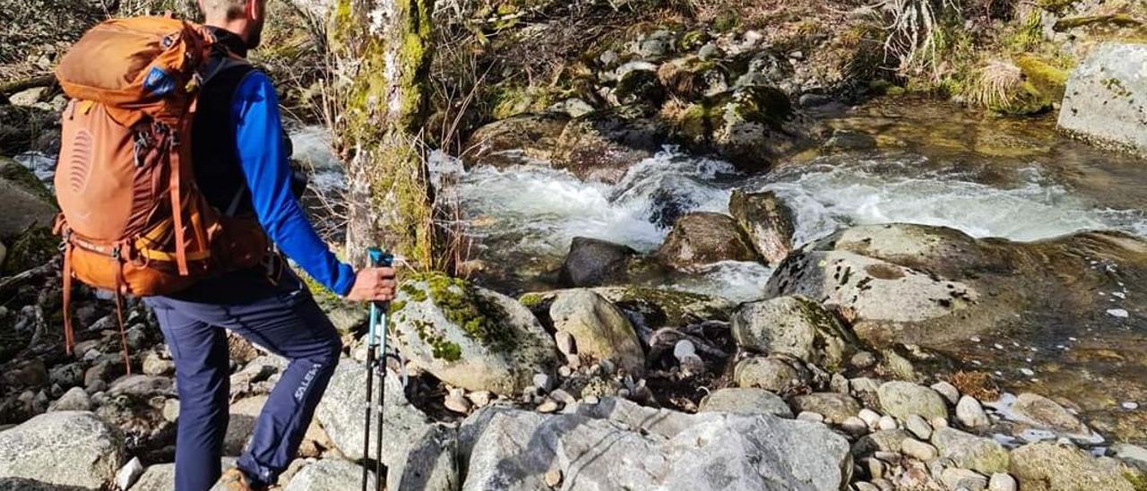 Peregrinos cruzan el regato a la entrada de Aciberos, en el Camino de Santiago