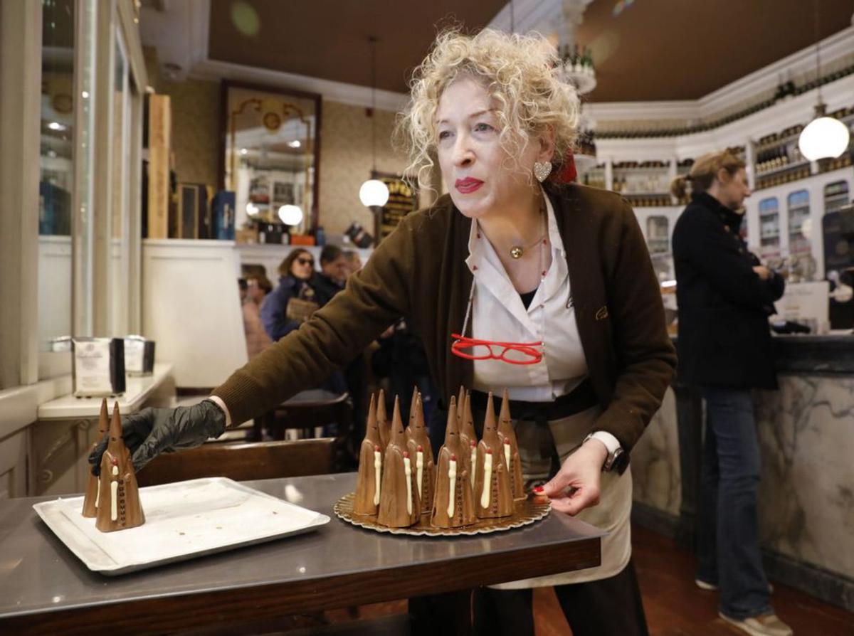 Carmen Gayo, colocando nazarenos de chocolate en Camilo de Blas. | FERNANDO RODRÍGUEZ