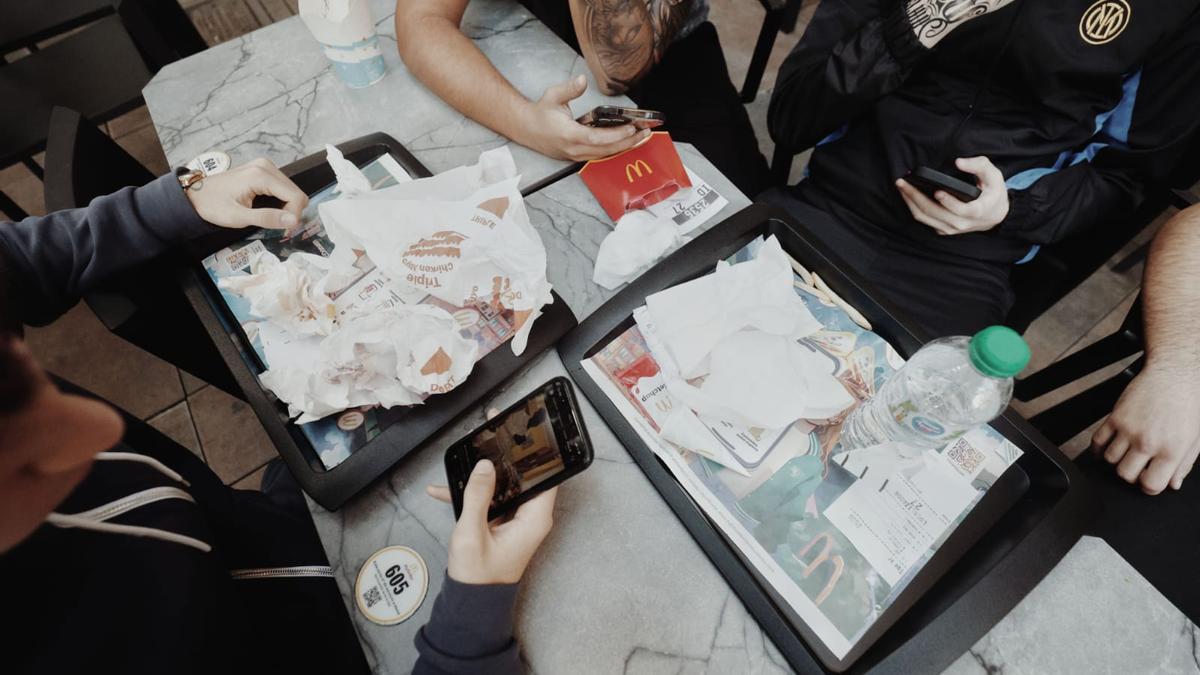 Adolescentes comen en un restaurante de cómida rápida en Palma.