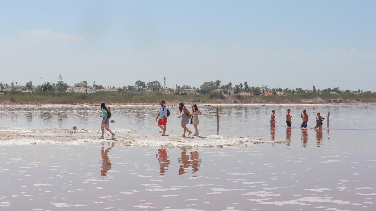 El baño y las fotos en redes sociales se alternan en la visita turística improvisada por cientos de visitantes este verano