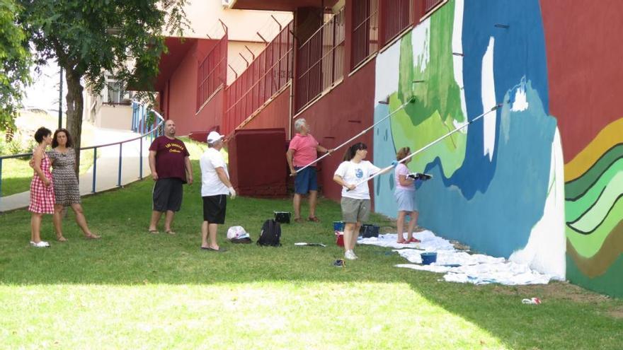 Un grupo de vecinos de Nueva Málaga, en plena realización del mural, en la calle Argentinita.