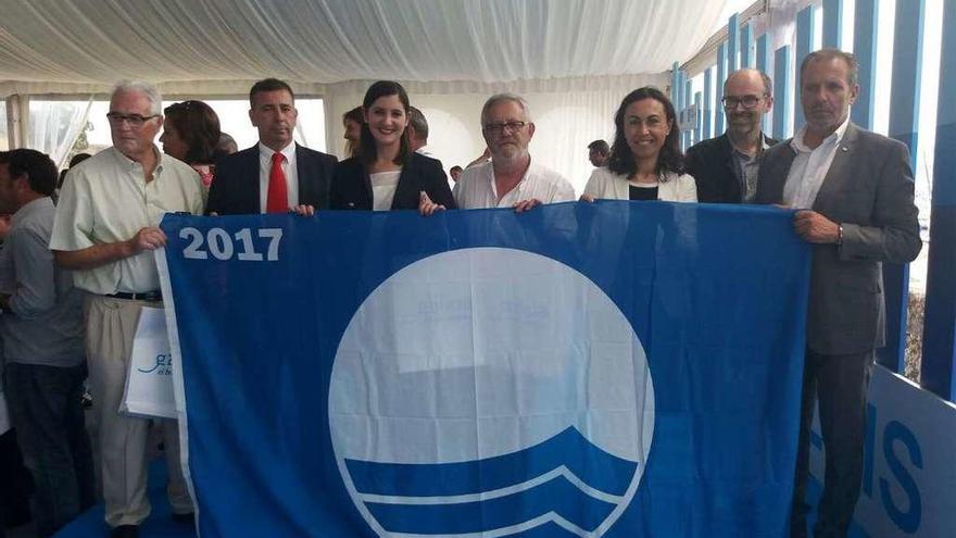 Los representantes de la comarca posan ayer en Baiona con una de las banderas azules. // FdV