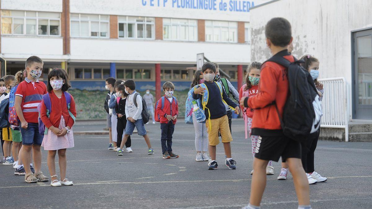 Niños con mascarilla en el patio del colegio.