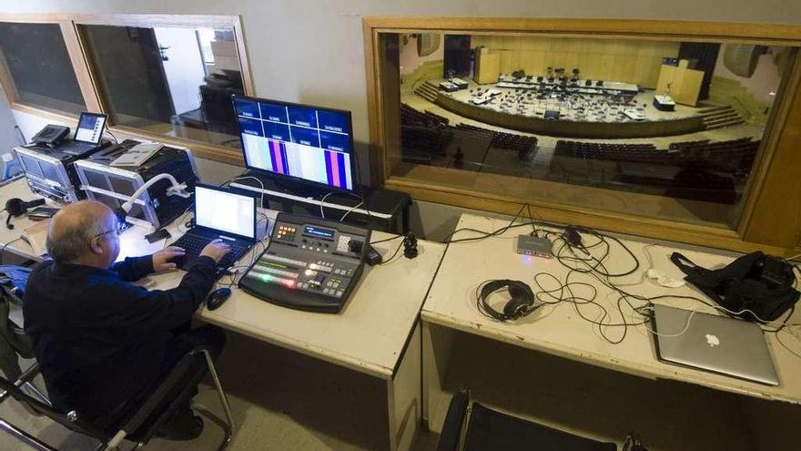 O técnico Antonio Cid, na sala de realización da Sinfónica, horas antes do concerto, ao lado, un dos músicos, na parte de atrás do escenario, mira cara ao público.