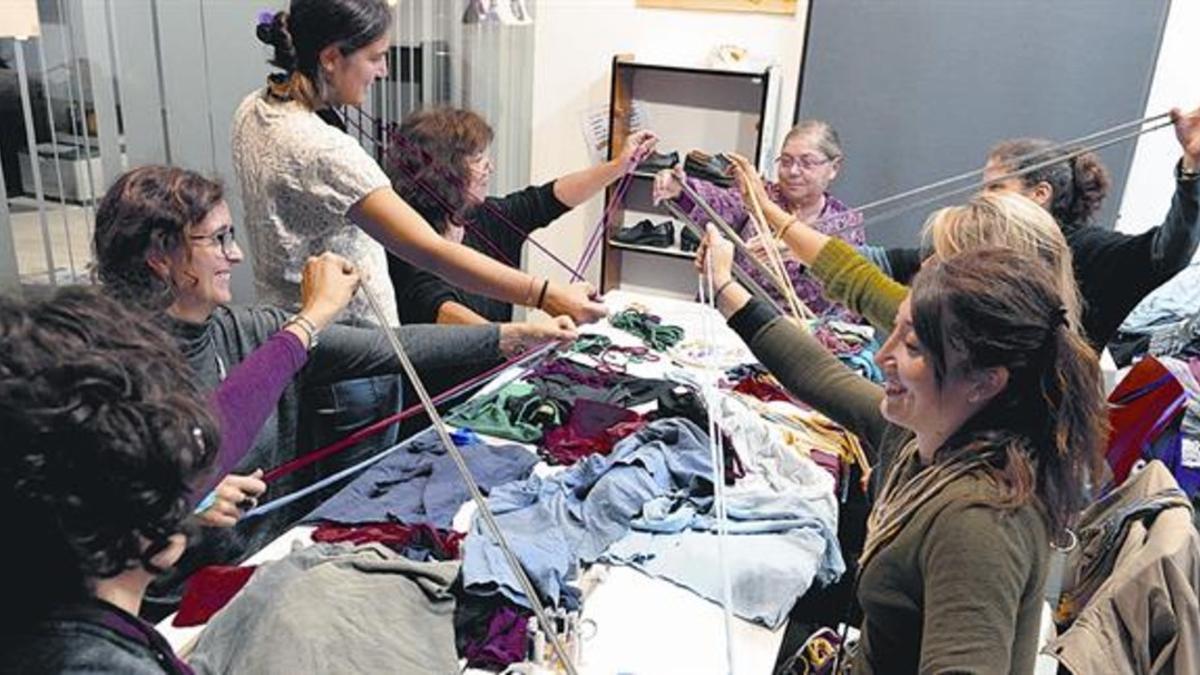 Un grupo de mujeres participa en un taller de costura con el objetivo de recuperar prendas usadas.