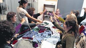 Un grup de dones participen en un taller de costura amb l’objectiu de recuperar peces usades.