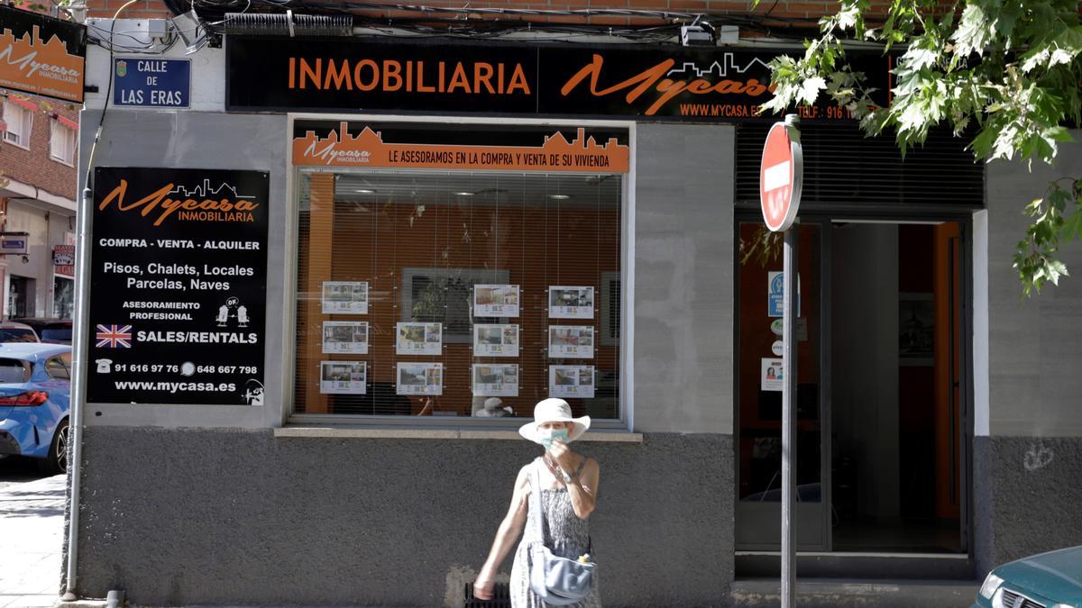 Una mujer consulta los anuncios de una inmobiliaria.