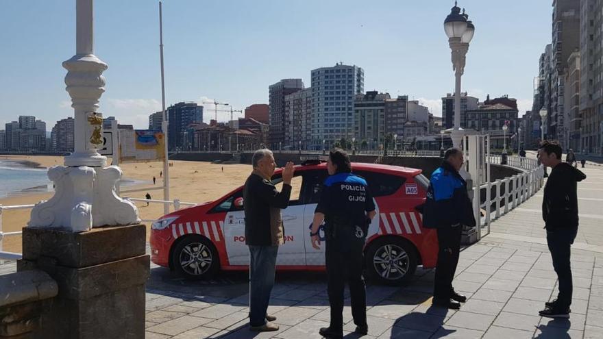 Una patrulla, por el Muro de San Lorenzo de Gijón, haciendo controles.