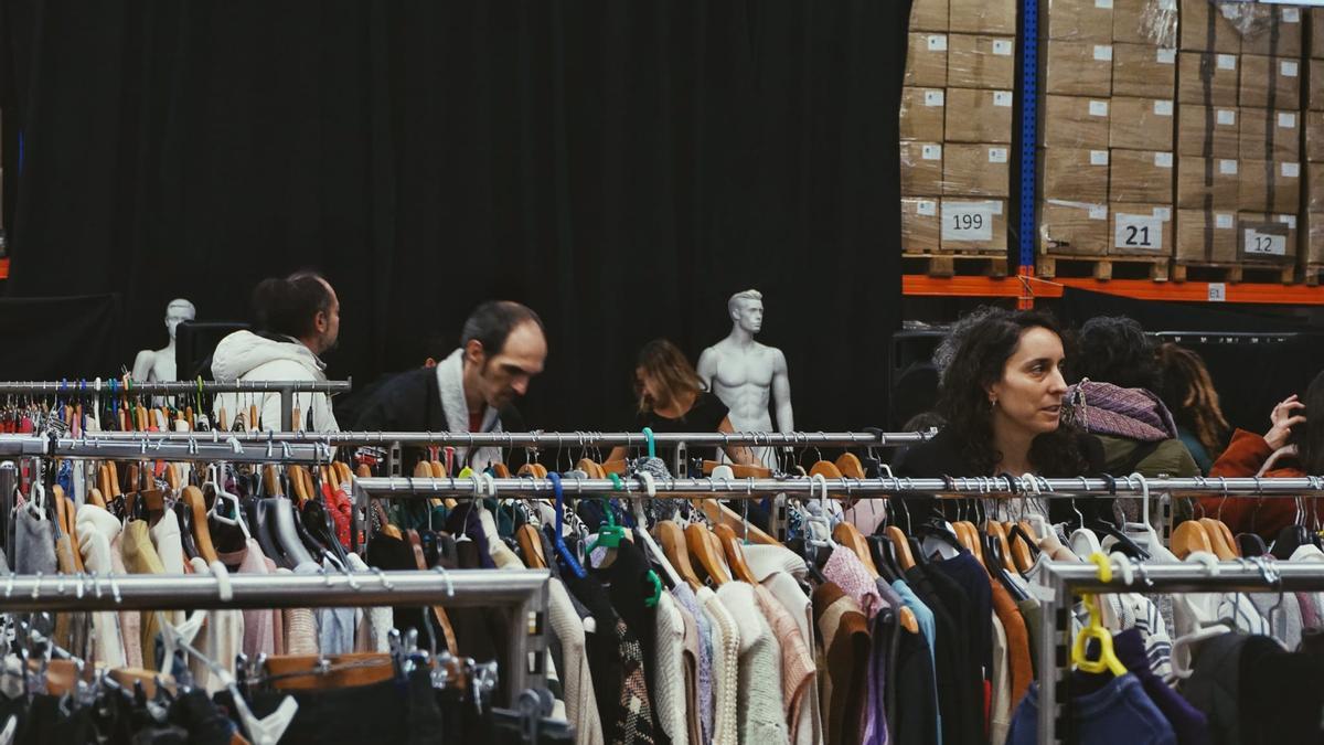 Varias personas 'ojean' la ropa de segunda mano a la venta en ARopa2.