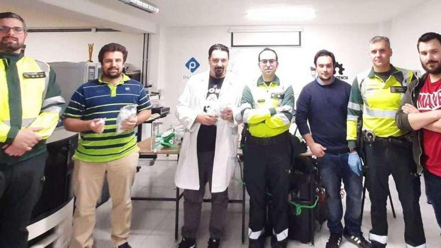 Los investigadores Carlos Moreno-Luque, Marcos Castillo, Juan María Piñera y Bartolomé López, el pasado jueves, en su laboratorio de Oviedo, con agentes de la Guardia Civil de Asturias que les donaron cien boquillas de etilómetros para su prototipo de respirador automático.