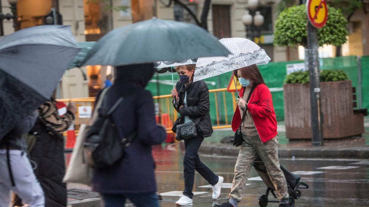 Un grupo de personas se protege de la lluvia en Alicante