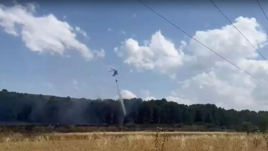 Un helicóptero de extinción realiza una descarga de agua en un incendio de Sádaba